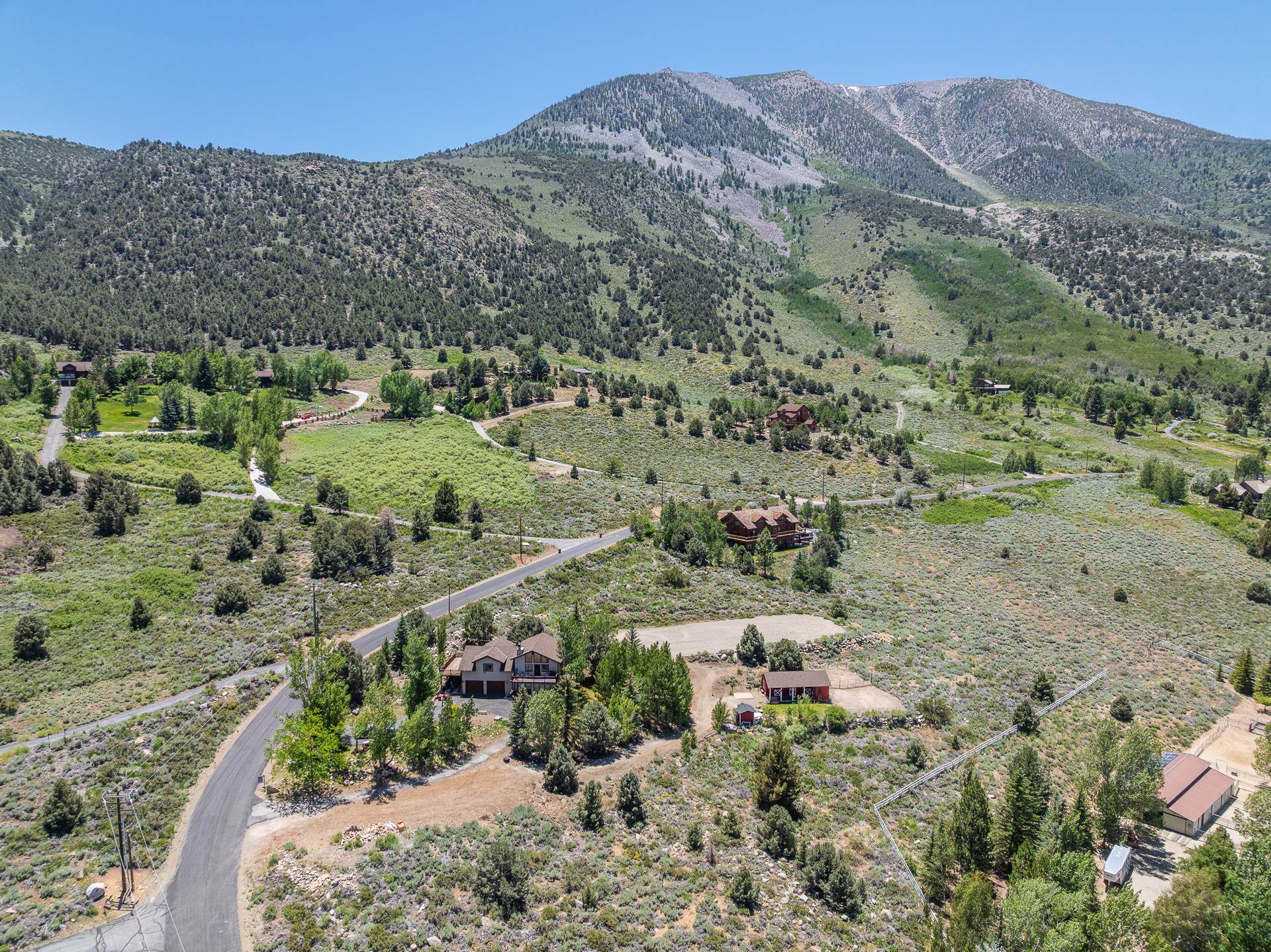537 Aspen Spring Ranch Road Mammoth Lakes, CA 93546 - Photo 38 of 40 Mountainous landscape with scattered properties, including a brown property with a dark roof and a red-roofed property