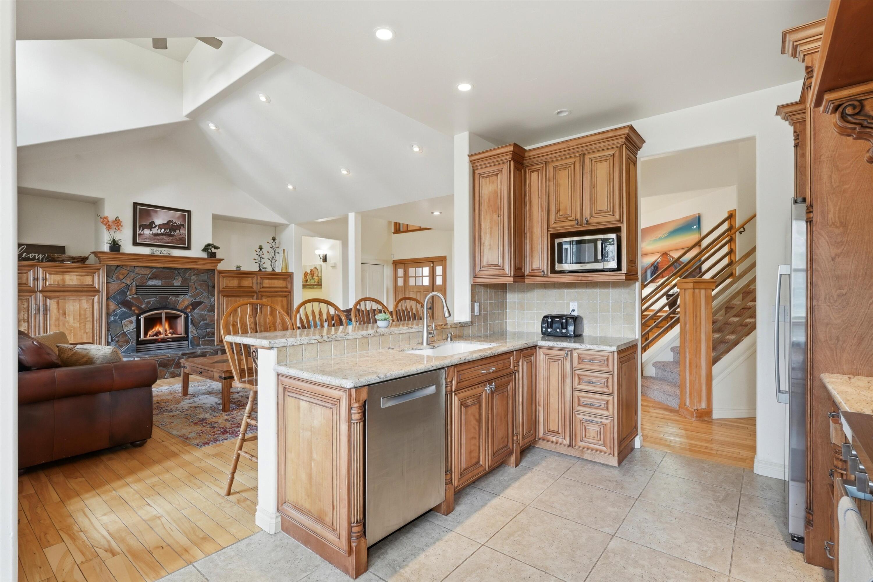 17179 Island Loop Way Bend, OR 97707 - Photo 14 of 52 a large white kitchen with stainless steel appliances granite countertop a couch and a view of living room
