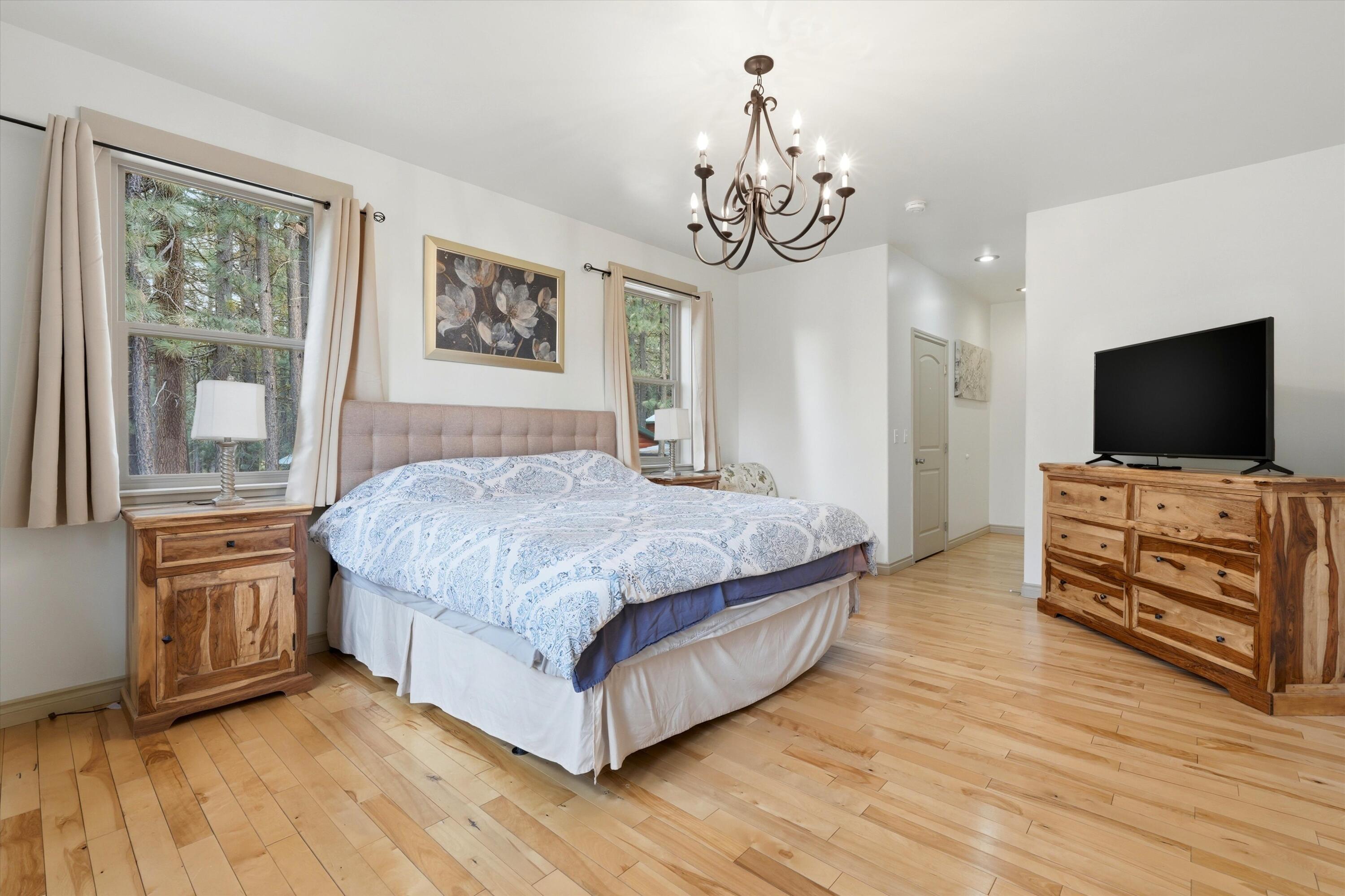 17179 Island Loop Way Bend, OR 97707 - Photo 24 of 52 a spacious bedroom with a bed and a flat screen tv