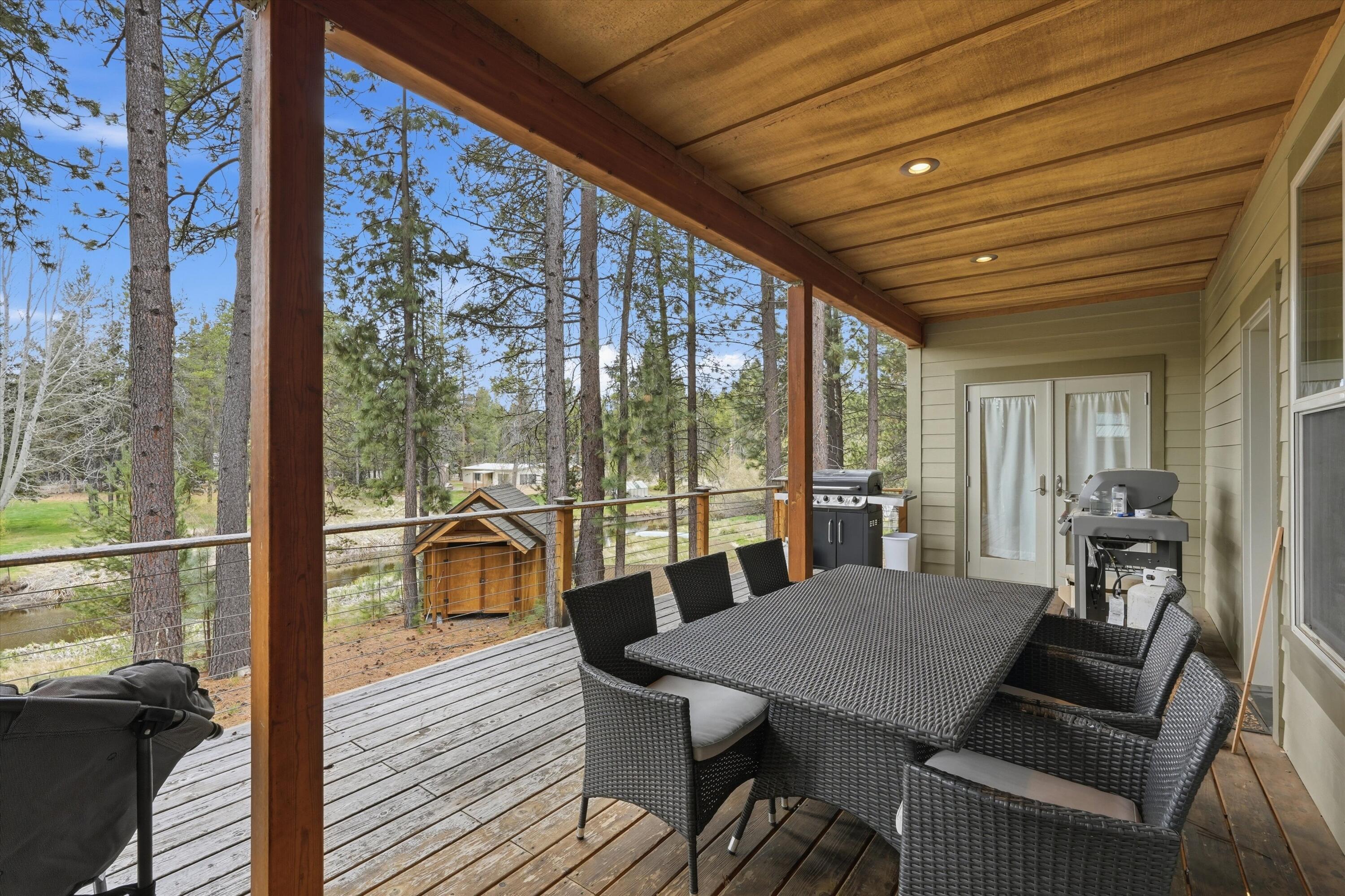 17179 Island Loop Way Bend, OR 97707 - Photo 37 of 52 a view of a dining room with furniture large windows and wooden floor