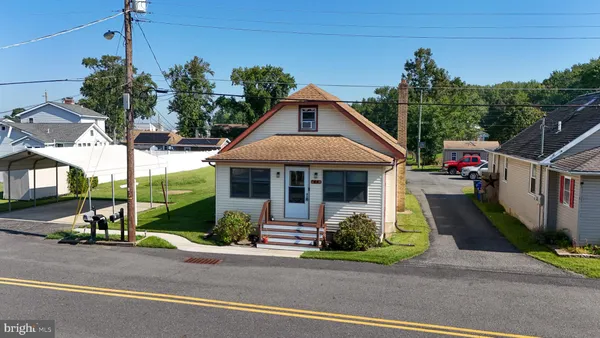 a front view of a house with a yard and potted plants