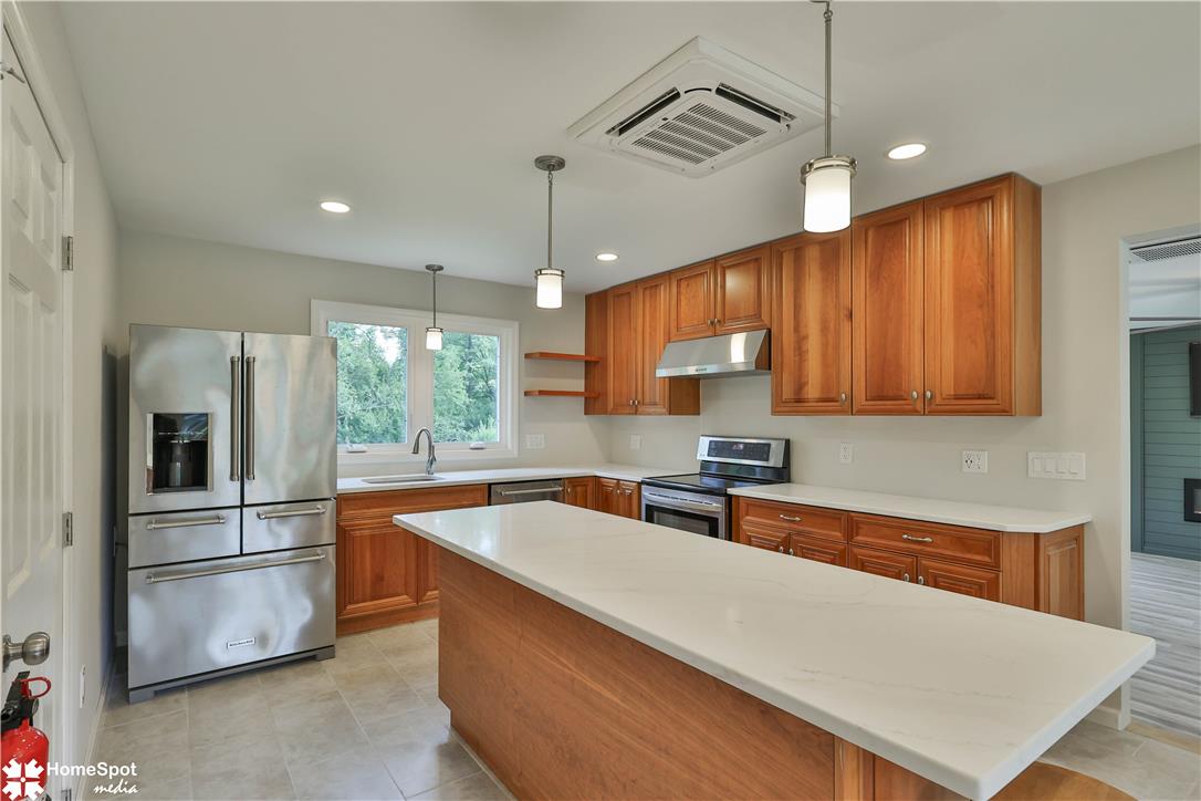 919 Point Phillips Road Bath, PA 18014 - Photo 10 of 59 A well-lit kitchen featuring warm wood cabinetry, modern stainless steel appliances, and a central island with a bright countertop.
