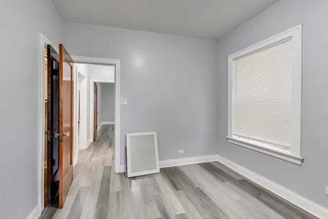 a view of a room with wooden floor and a window