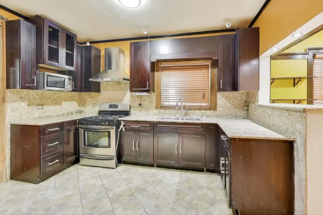 a kitchen with granite countertop a sink stove and cabinets