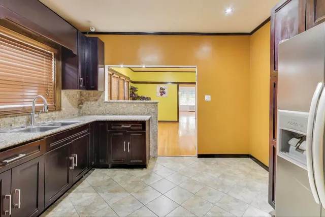 a kitchen with granite countertop a sink and a refrigerator