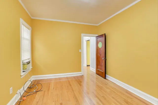 a view of a room with wooden floor and a window
