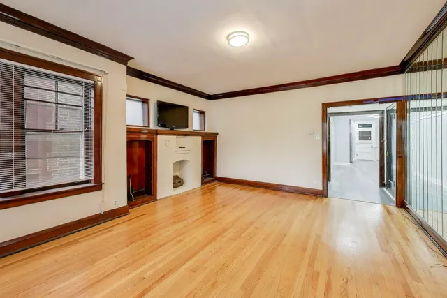 a view of empty room with wooden floor and fan