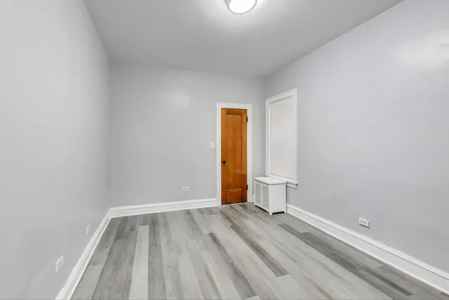 a view of room with walk in closet and wooden floor