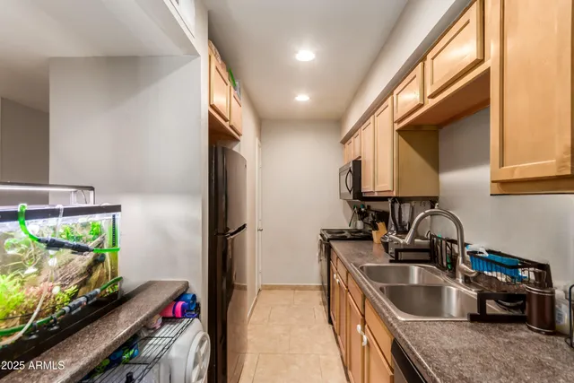 a kitchen with kitchen island granite countertop a sink appliances and cabinets