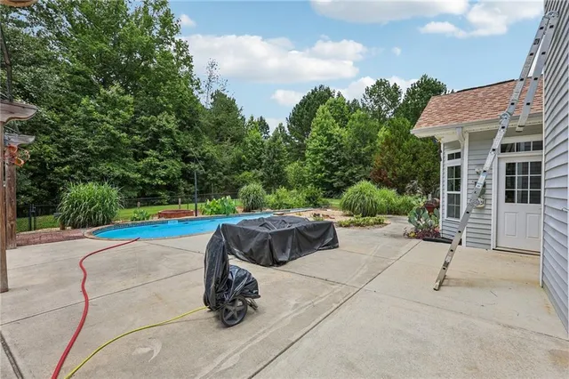 a view of house with swimming pool outdoor seating and green space