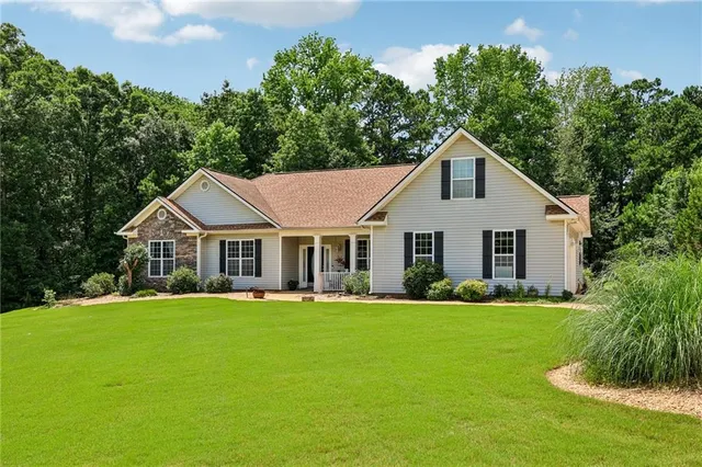 a front view of a house with a yard and trees