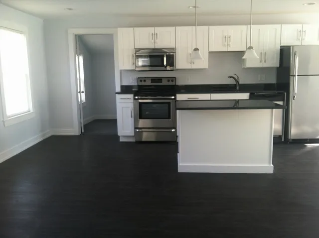 a kitchen with stainless steel appliances a stove a sink and a refrigerator