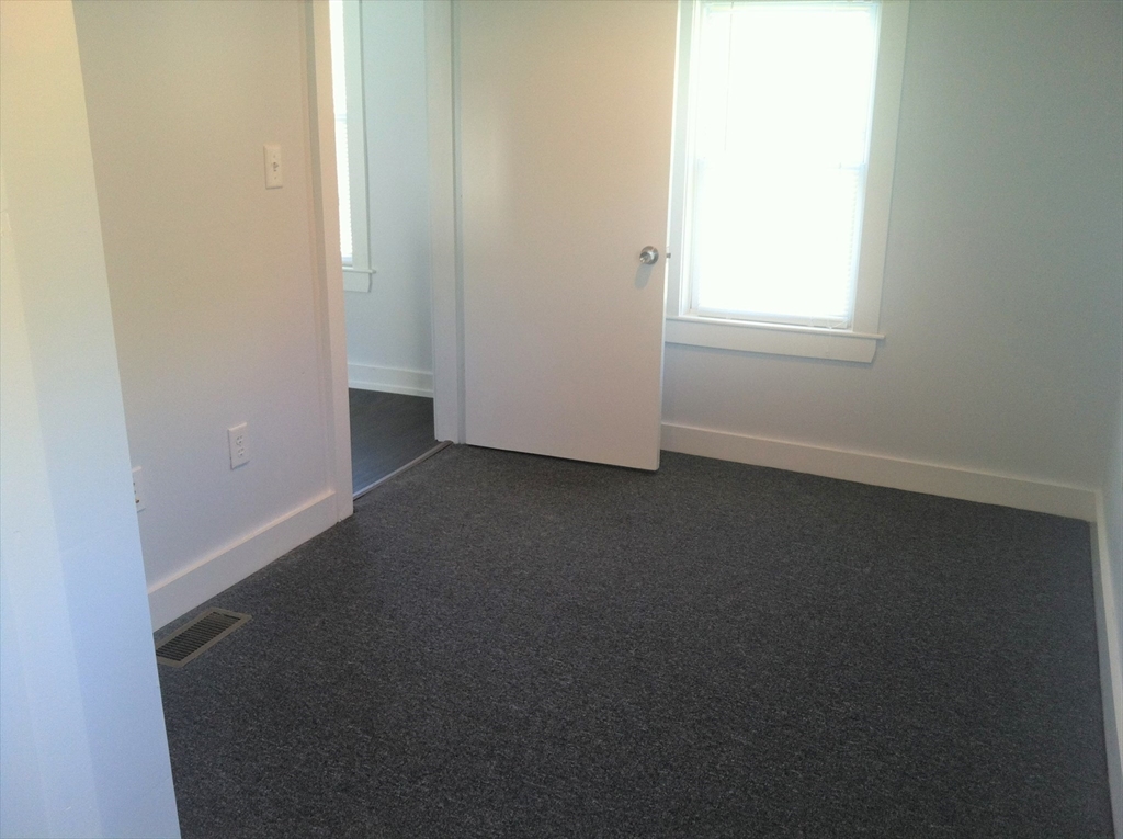 158 Main Street, Unit 2 Wenham, MA 01984 - Photo 10 of 13 an empty room with windows