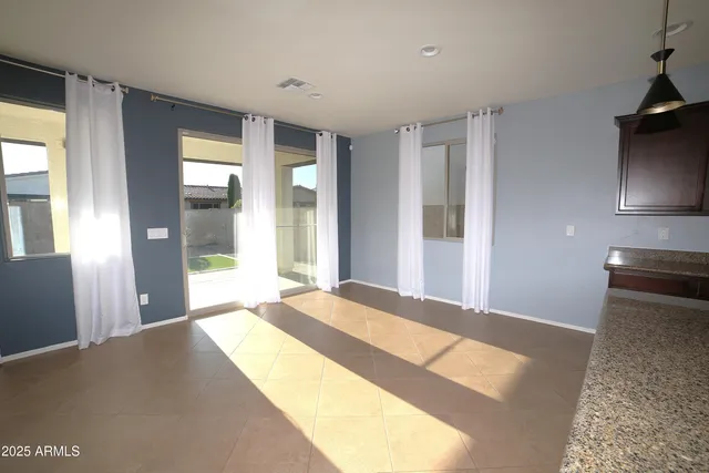 a kitchen with stainless steel appliances granite countertop a sink a oven a dining table and chairs