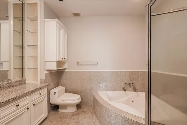 a bathroom with a granite countertop toilet a sink and bathtub