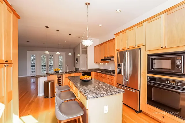 a kitchen with stainless steel appliances granite countertop a stove refrigerator and cabinets