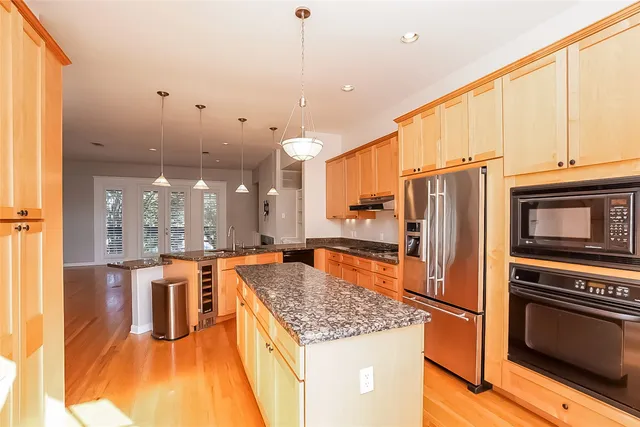 a kitchen with stainless steel appliances granite countertop a sink a stove and a refrigerator