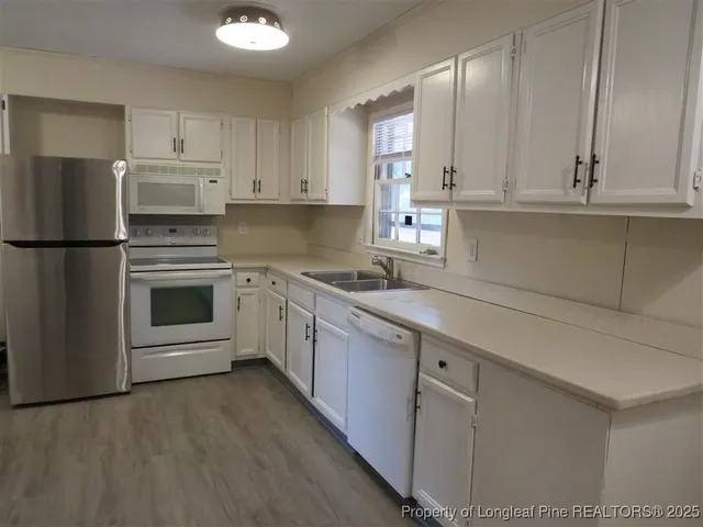a kitchen with cabinets stainless steel appliances and a counter space