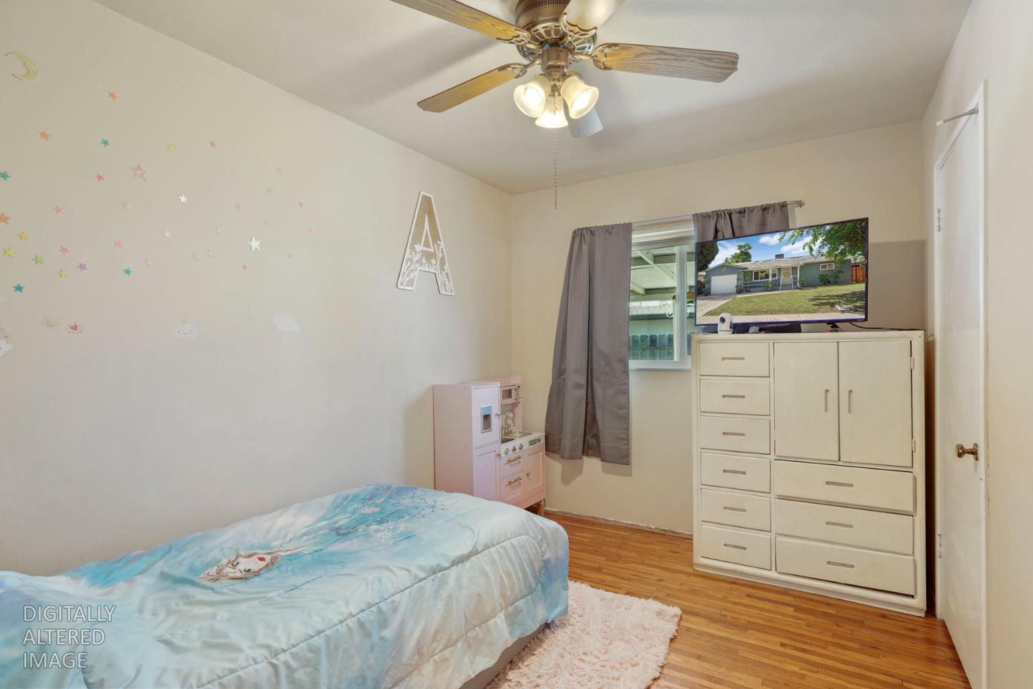 152 Drake Avenue Modesto, CA 95350 - Photo 17 of 52 a bedroom with a bed and a flat tv screen on dresser
