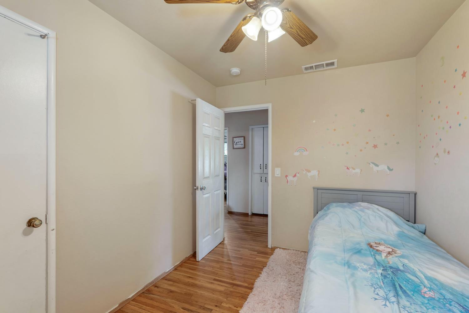 152 Drake Avenue Modesto, CA 95350 - Photo 18 of 52 a bedroom with a bed and a chandelier
