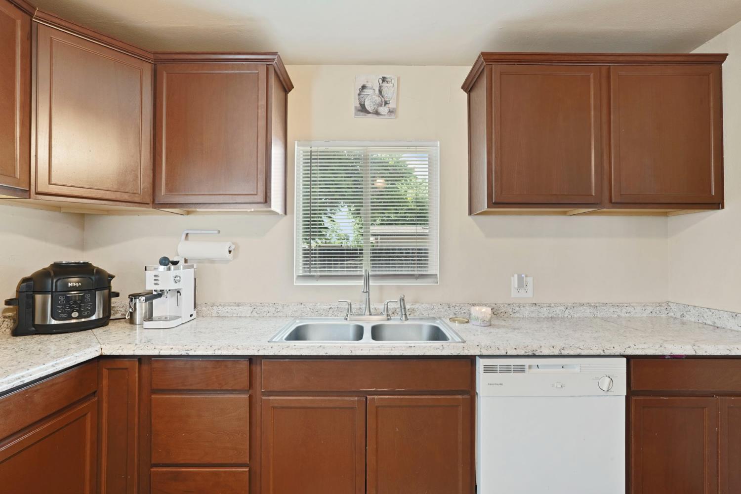 152 Drake Avenue Modesto, CA 95350 - Photo 9 of 52 a kitchen with granite countertop cabinets sink and window
