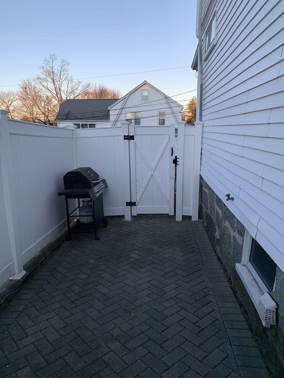 93 Waldeck Road Milton, MA 02186 - Photo 25 of 30 a view of a house with a small yard and wooden fence