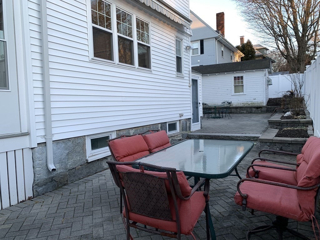 93 Waldeck Road Milton, MA 02186 - Photo 26 of 30 a backyard of a house with wooden table and chairs