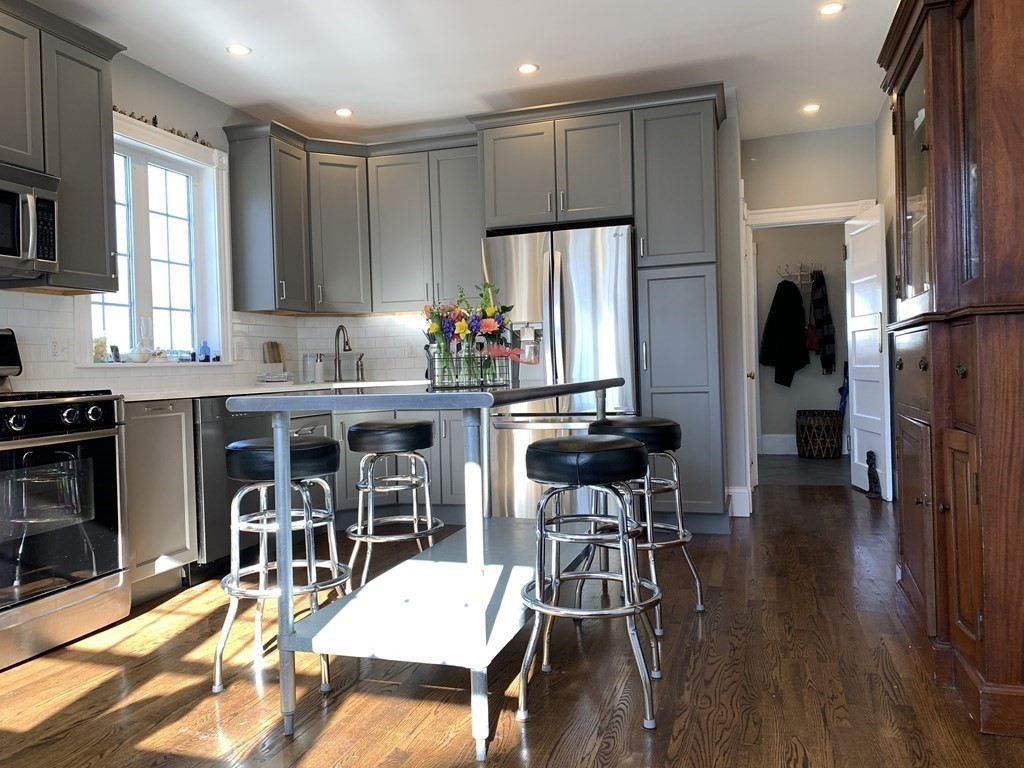93 Waldeck Road Milton, MA 02186 - Photo 5 of 30 a view of a dining room with furniture and a kitchen view