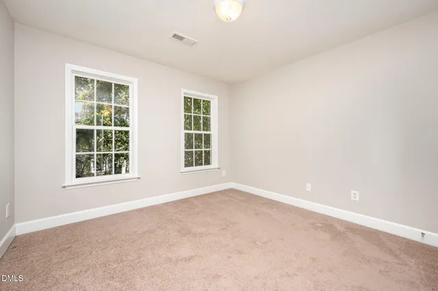 an empty room with fan and windows