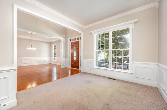 a view of an empty room with window and wooden floor
