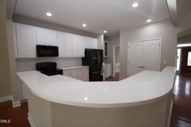a view of empty room with wooden floor and fireplace