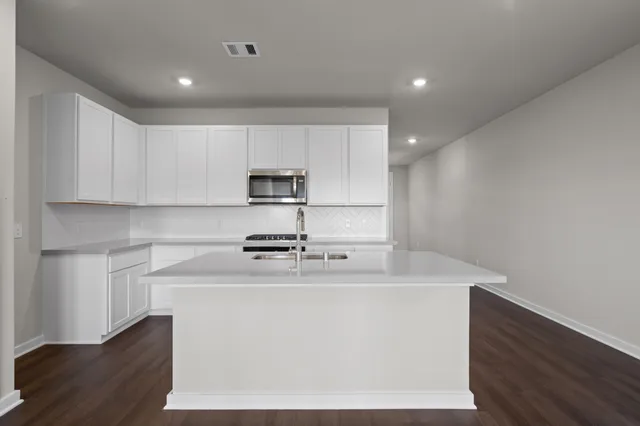 a white kitchen with wooden floor