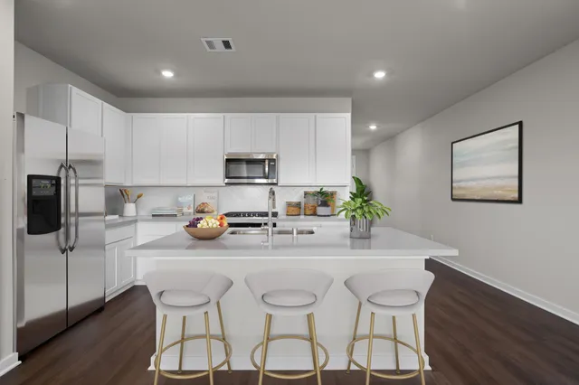 a kitchen with stainless steel appliances a microwave a stove a table and chairs