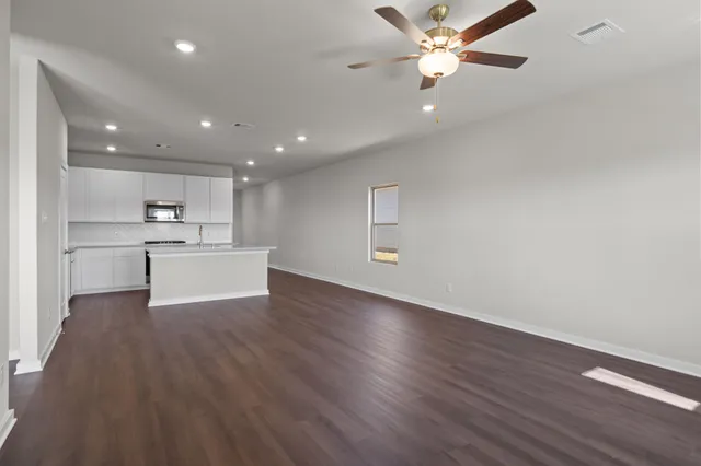 a view of a kitchen with wooden floor and a kitchen space