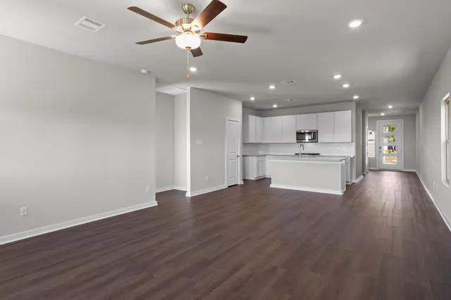 an open kitchen with a white appliances and wooden floor