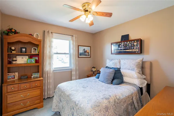 a bedroom with a bed and a window with a bookshelf