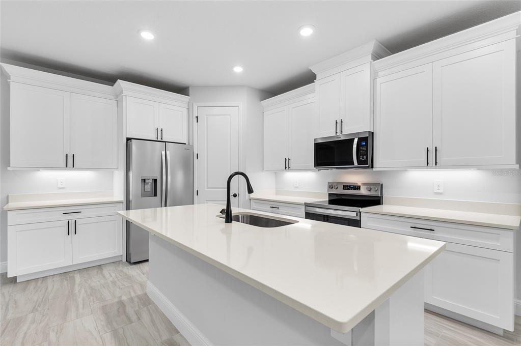 371 Miller Road Sanford, FL 32773 - Photo 11 of 50 a kitchen with a sink a stove and white cabinets