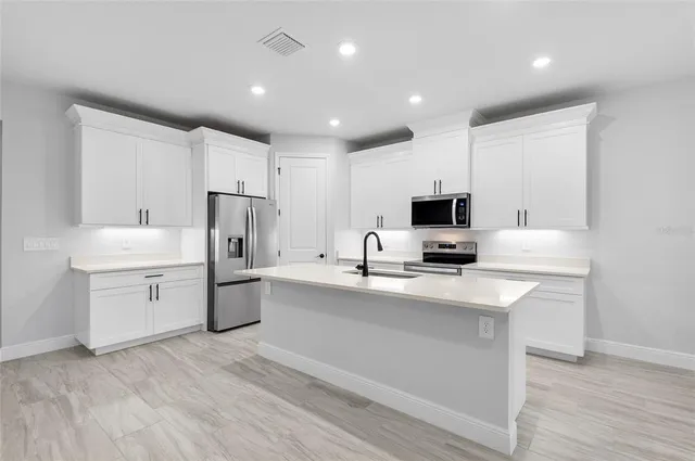 a kitchen with a sink stainless steel appliances and cabinets