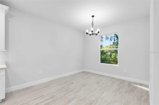 an empty room with wooden floor mirror and window