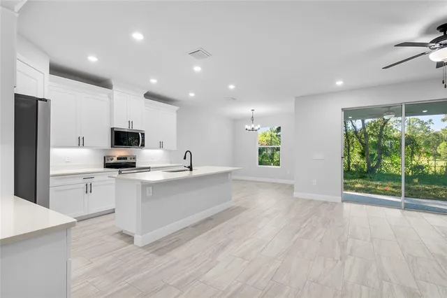 a large kitchen with stainless steel appliances a large counter top and a wooden floors
