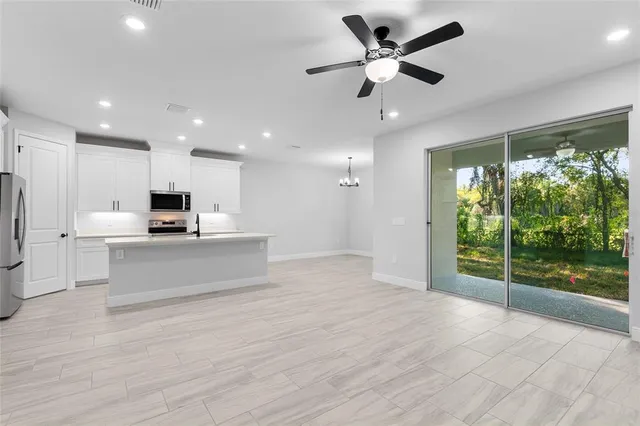 a view of kitchen with stainless steel appliances kitchen island granite countertop a stove and a refrigerator