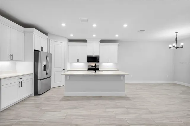 a view of kitchen with wooden floor stainless steel appliances and cabinets