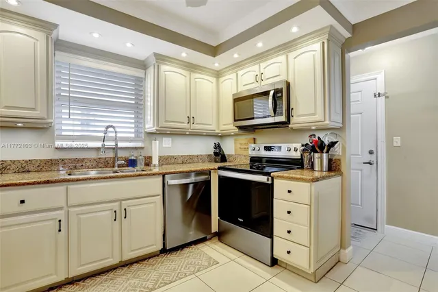 a kitchen with stainless steel appliances granite countertop a stove a sink and a microwave