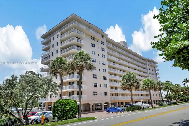 a view of a building with a yard and car parked