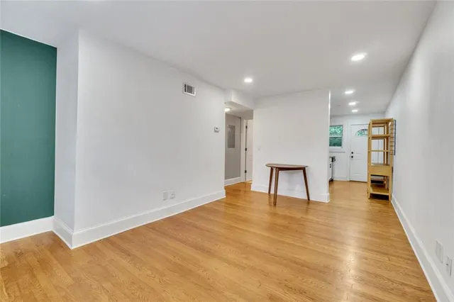 a view of an empty room with wooden floor