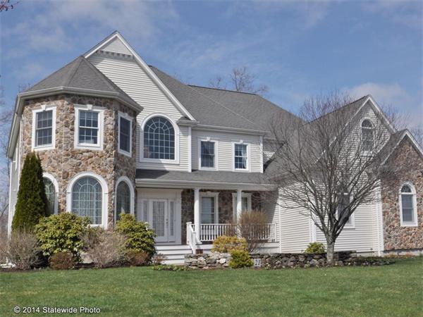 a front view of a house with a yard and trees