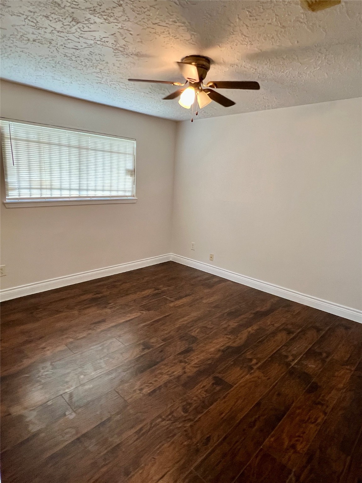 12110 Murr Way Houston, TX 77048 - Photo 15 of 24 an empty room with wooden floor fan and windows