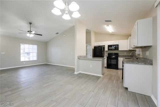 a view of kitchen with sink microwave and cabinets