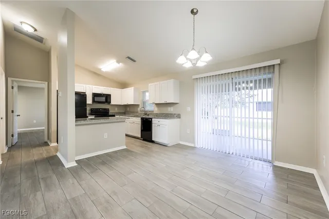 a view of a kitchen with a sink wooden floor and stainless steel appliances