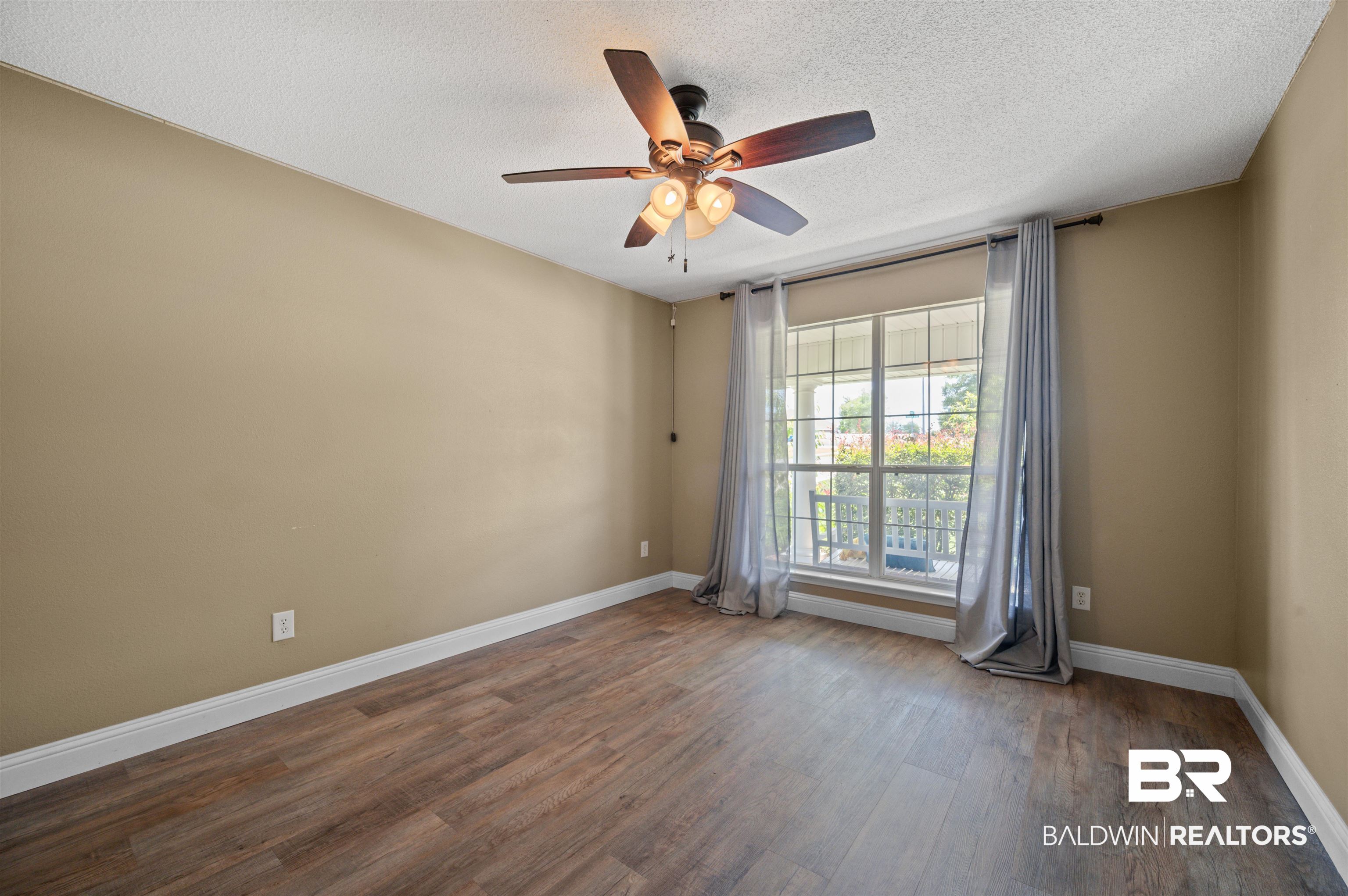 11705 Venice Boulevard Foley, AL 36535 - Photo 20 of 43 Empty room with a textured ceiling, ceiling fan, and dark hardwood / wood-style flooring